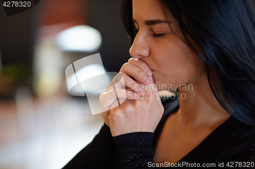 Image of close up of unhappy woman praying god at funeral