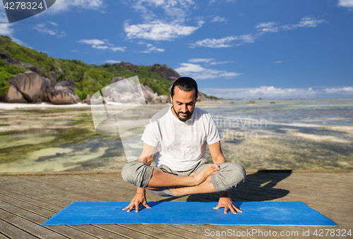 Image of man making yoga in scale pose outdoors