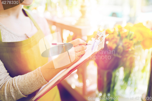 Image of close up of woman with clipboard at flower shop