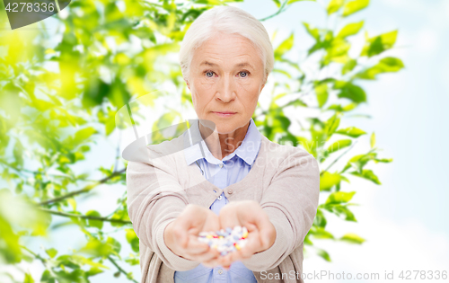 Image of senior woman with medicine at home