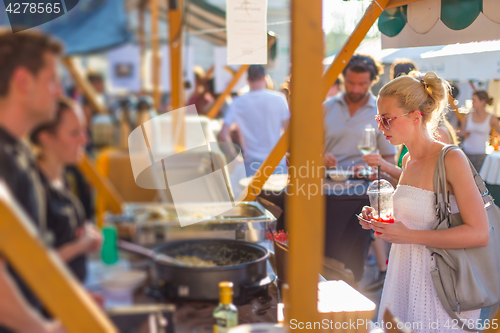 Image of Woman buying meal at street food festival.