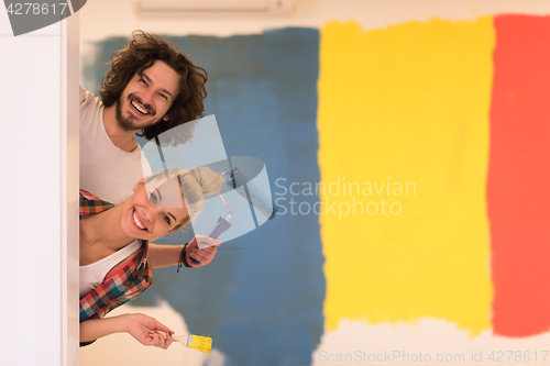 Image of portrait of a couple painting interior wall