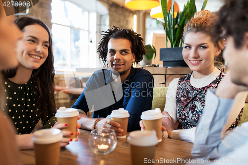 Image of happy friends drinking coffee at restaurant