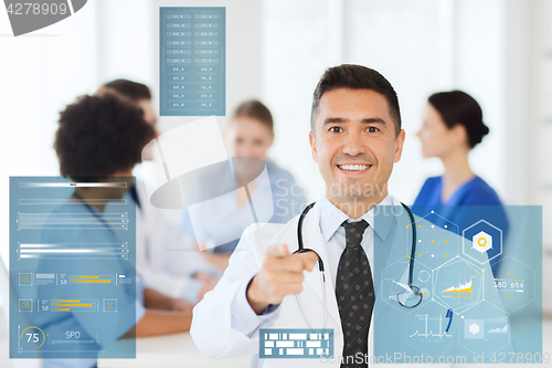 Image of happy doctor over group of medics at hospital