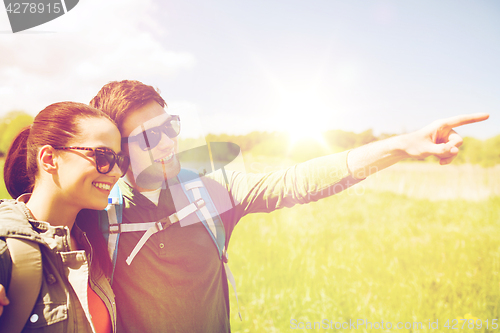 Image of happy couple with backpacks hiking outdoors
