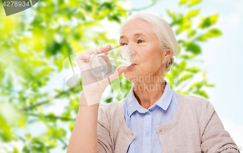 Image of happy senior woman with glass of water at home
