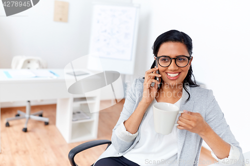 Image of businesswoman calling on smartphone at office