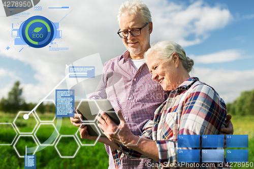 Image of happy senior couple with tablet pc at summer farm