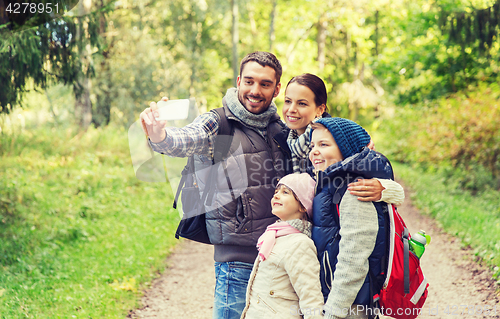 Image of family with backpacks taking selfie by smartphone