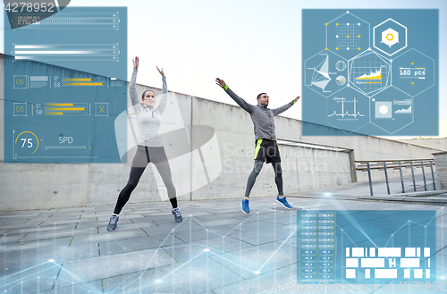 Image of happy man and woman jumping outdoors