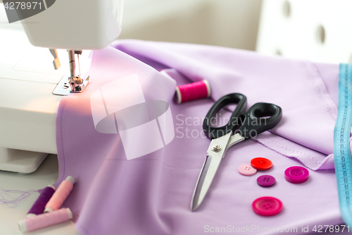 Image of sewing machine, scissors, buttons and fabric