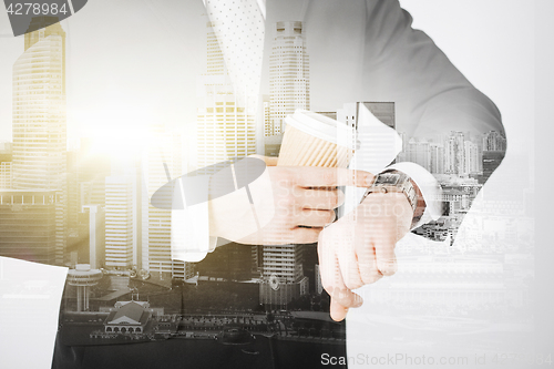 Image of close up of businessman with wristwatch and coffee