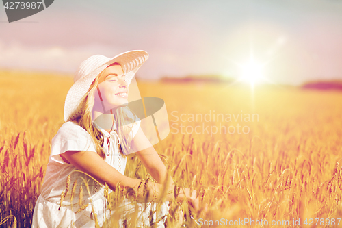 Image of happy young woman in sun hat on cereal field