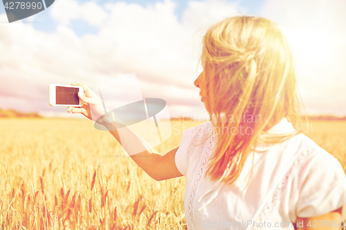 Image of close up of girl with smartphone on cereal field