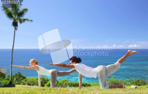 Image of couple making yoga balancing table pose outdoors
