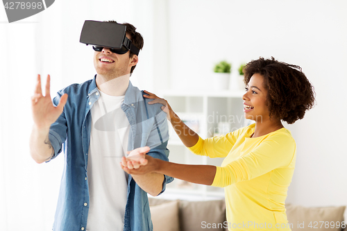 Image of happy couple with virtual reality headset at home