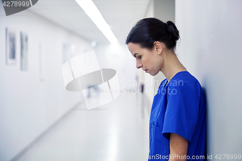 Image of sad female nurse at hospital corridor