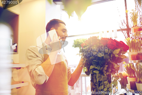 Image of man with smartphone and red roses at flower shop
