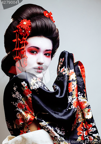 Image of young pretty geisha in kimono with sakura and red decoration design on white background