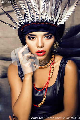 Image of young pretty woman with make up like red indian, futher in hair,