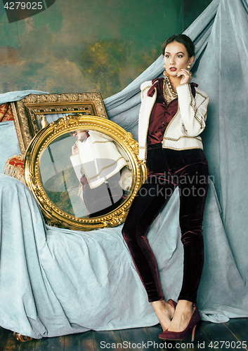Image of beauty rich brunette woman in luxury interior near empty frames,