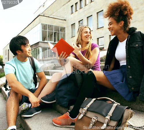 Image of cute group of teenages at the building of university with books 