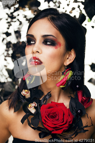 Image of pretty brunette woman with rose jewelry, black and red, bright m