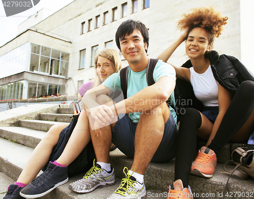 Image of cute group of teenages at the building of university with books 