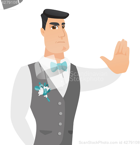 Image of Young caucasian groom showing stop hand gesture.