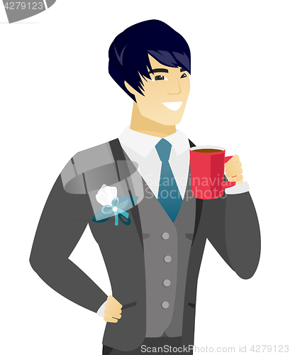 Image of Young asian groom holding cup of coffee.