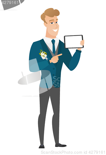 Image of Smiling groom holding tablet computer.