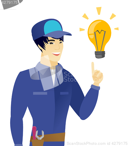 Image of Young asian mechanic pointing at idea light bulb.