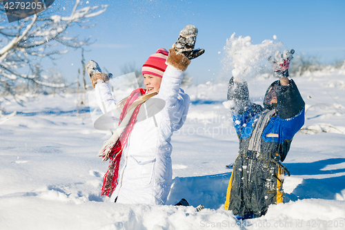 Image of Happy little children playing  in winter snow day.