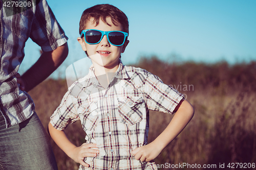 Image of Father and son playing on the field at the day time.