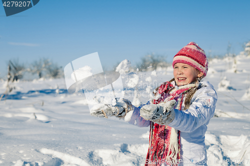 Image of Happy little girl playing  on winter snow day.