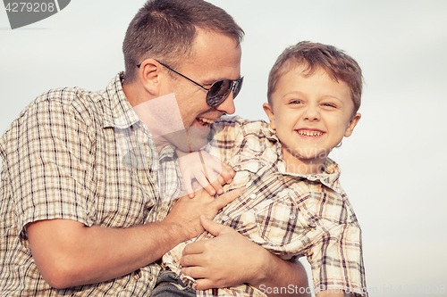 Image of Father and son playing on the beach at the day time.