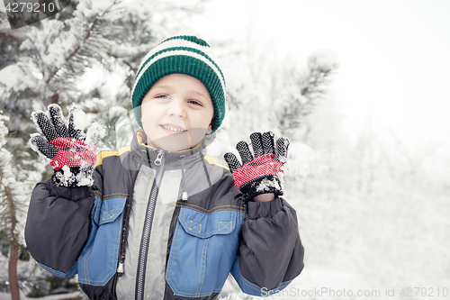 Image of Happy little boy playing  on winter snow day.