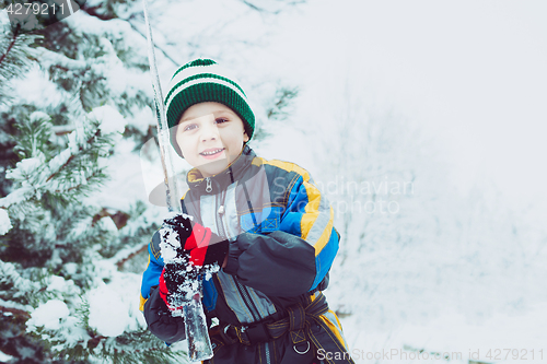 Image of Happy little boy playing  on winter snow day.