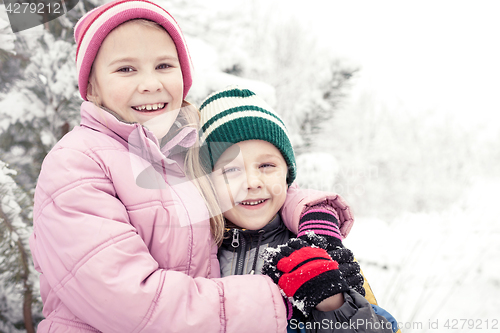 Image of Happy little children playing  in winter snow day.