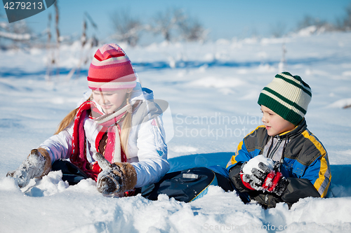 Image of Happy little children playing  in winter snow day.