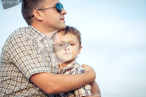 Image of Father and son playing on the field at the day time.