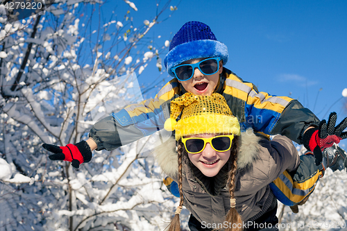 Image of Happy little children playing  in winter snow day.