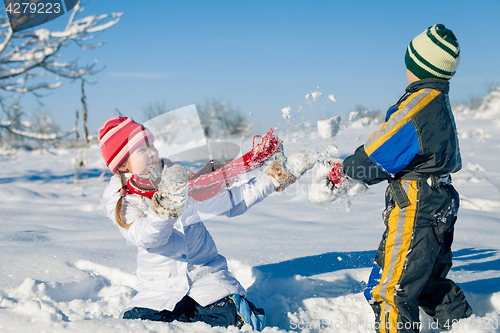 Image of Happy little children playing  in winter snow day.