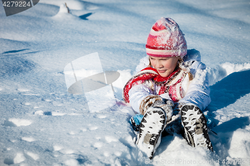 Image of Happy little girl playing  on winter snow day.