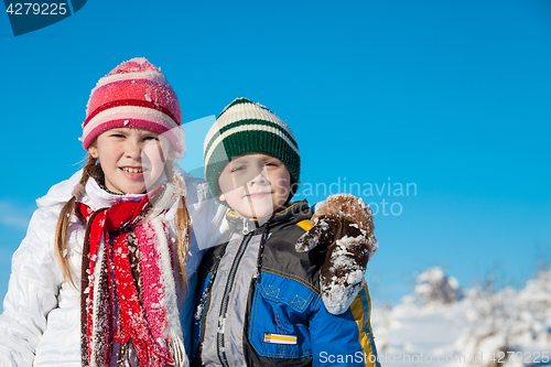 Image of Happy little children playing  in winter snow day.