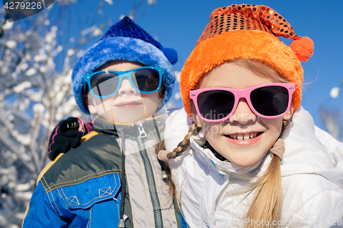 Image of Happy little children playing  in winter snow day.