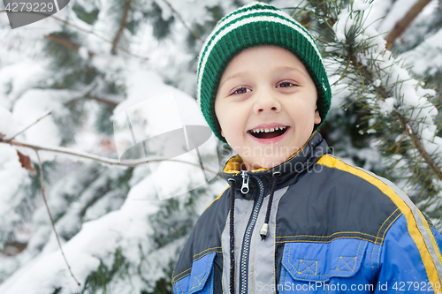 Image of Happy little boy playing  on winter snow day.