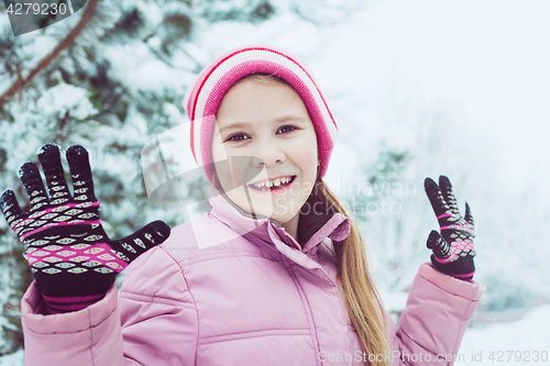 Image of Happy little girl playing  on winter snow day.