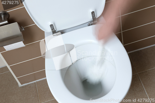 Image of White toilet bowl in the bathroom, cleaning with toiletbrush