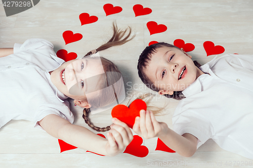 Image of  little boy and girl lying on the floor.